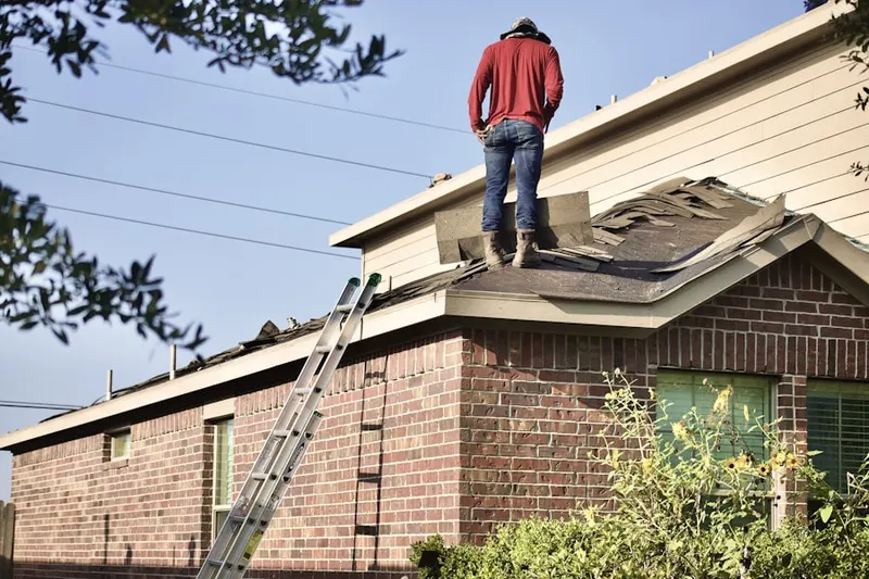 Professional roofer working on a residential roof in Falls